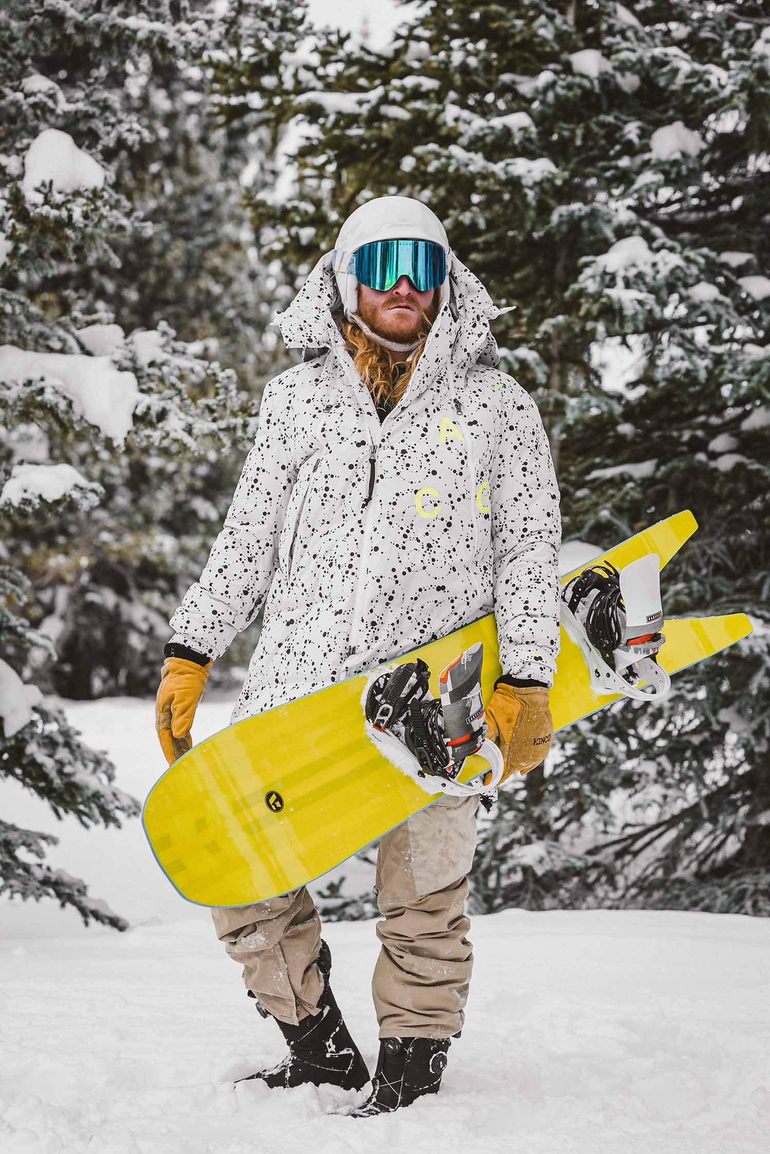 a person in snow gear holding a snowboard